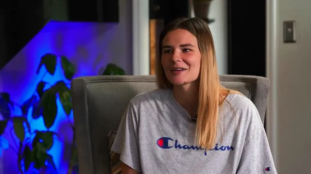 A woman seated for an interview, smiling slightly as she talks.