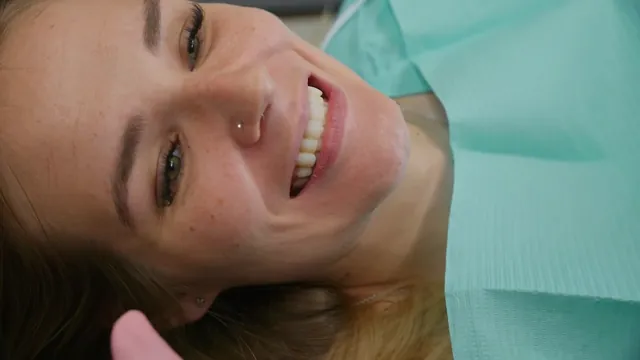 The patient smiles widely in a dental chair.
