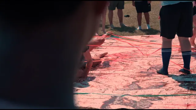 Feet and legs on a paint-splattered tarp during a field game.