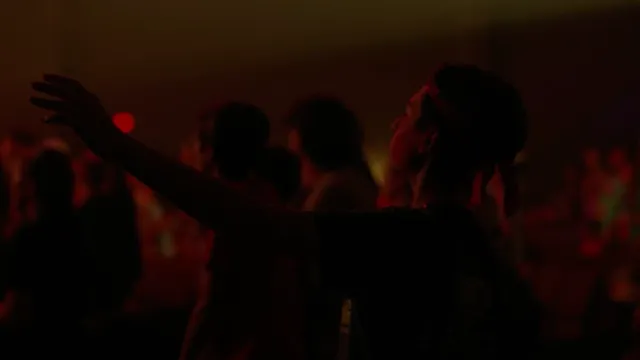 A silhouette with a raised arm in red light.